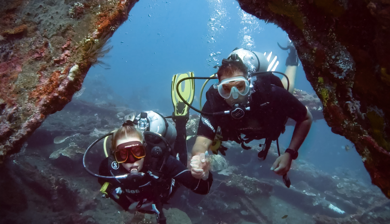 Two scuba divers exploring the underwater wreck site in Tulamben, Bali.