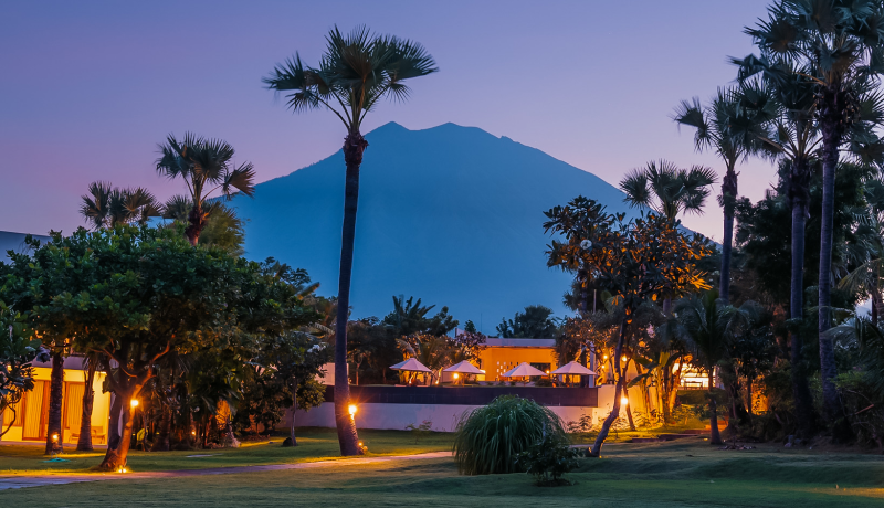 Evening view of a serene resort in Tulamben, Bali, with Mount Agung in the background.