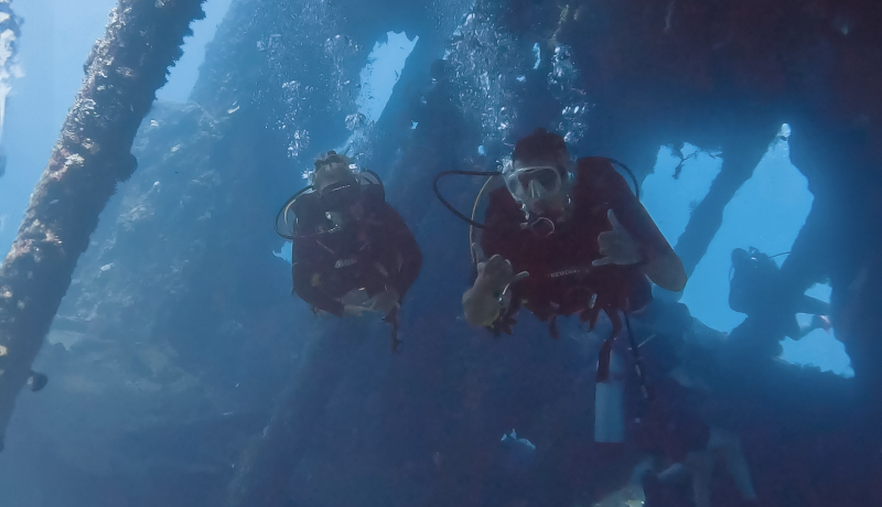 Two scuba divers navigating the iconic shipwreck in Tulamben, Bali.